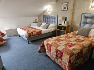 a hotel room with two beds in a room at Logis Hôtel-Restaurant Le Val d'Amby in Hières-sur-Amby