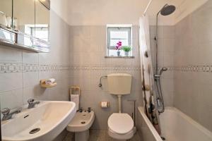 a bathroom with a sink and a toilet and a tub at Maison de vacances Casa Rocha in Armação de Pêra +23 photos