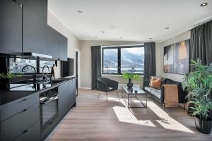 a kitchen and living room with a couch at TotalApartments Vervet Apartment Hotel in Tromsø