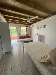 a bedroom with a bed and a couch in it at Villa Mamour in Case-Pilote