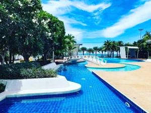 a swimming pool with a blue tile floor and trees at Beautiful 1bedroom 35sqm sea view floor17th jomtien Lumpini in Jomtien Beach