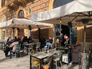 a group of people sitting at tables outside a building at B&B Rome Vatican Residence in Rome