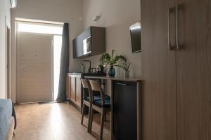 cocina con encimera y sillas en una habitación en Monolocale Real Valle Blue, en Scafati