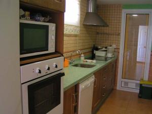 a kitchen with a microwave on top of a stove at Apartamento con Piscina in Tarifa