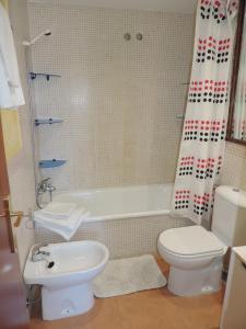 Un baño con inodoro, bañera y lavabo. en Apartamento con Piscina, en Tarifa