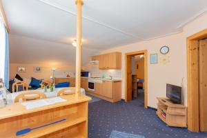 a kitchen and a living room with a table at Haus Traudi in Rauris