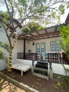 a patio of a house with a bench and a tree at CasaLuna in Kamburugamuwa