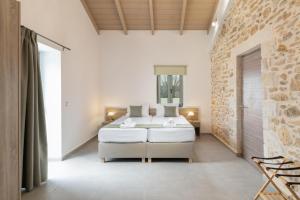 a bedroom with a bed and a stone wall at Villa Lakioto in Dhémbla