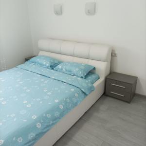 a bedroom with a bed with blue sheets and a nightstand at Vera's Apartment in Timişoara