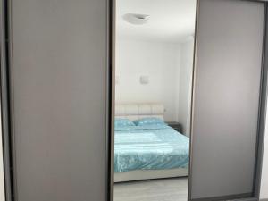 a mirror in front of a bed in a bedroom at Vera's Apartment in Timişoara