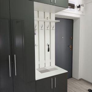 a kitchen with black cabinets and a white counter top at Vera's Apartment in Timişoara