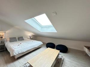 a bedroom with a bed and a skylight at Le pilier G un cocon confortable proche du centre in Reims