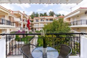 einen Tisch und Stühle auf einem Balkon mit Gebäuden in der Unterkunft Beachfront Bliss by halu! Spacious vacation house in Nea Skioni