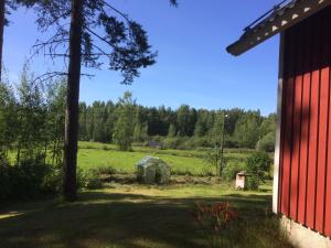 a view of a red barn and a field at Lomatalo Aurinkorinne Punkaharjulla in Punkaharju