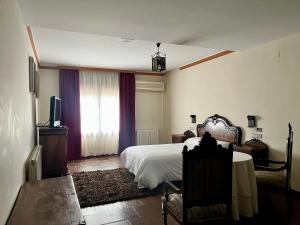 a bedroom with a bed and a table and a window at Cella del Palancar in Motilla del Palancar
