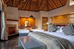 a bedroom with two beds and a fireplace at Muluwa Lodge in White River +65 photos