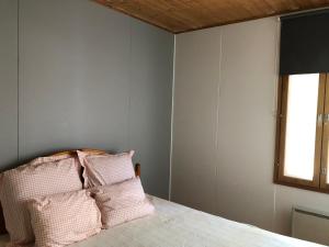 a bedroom with a bed with pink and white pillows at Lomatalo Aurinkorinne Punkaharjulla in Punkaharju