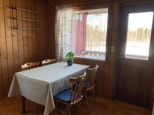 une table de salle à manger avec des chaises et une plante en pot dessus dans l'établissement Lomatalo Aurinkorinne Punkaharjulla, à Punkaharju