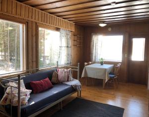 a living room with a couch and a table at Lomatalo Aurinkorinne Punkaharjulla in Punkaharju +6 photos
