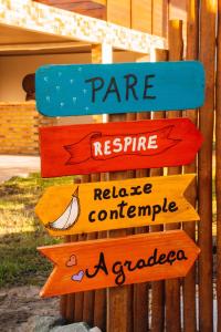 a group of signs on a wooden pole at Pousada Rancho Matos in Santo Amaro
