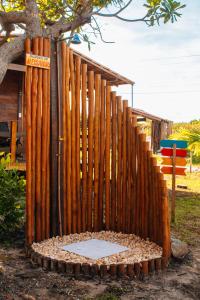 a fence made out of logs next to a tree at Pousada Rancho Matos in Santo Amaro