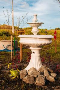 a white fountain in a garden with a stop sign at Pousada Rancho Matos in Santo Amaro +28 photos