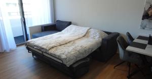 een kleine slaapkamer met een bed en een stoel bij Forst & Flair Apartment in Bad Harzburg