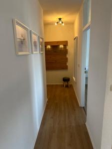 een hal met witte muren en een houten vloer bij Forst & Flair Apartment in Bad Harzburg