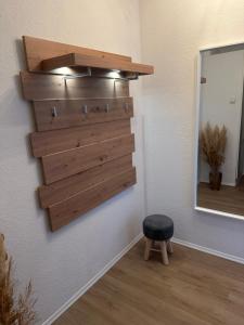 een plank op een muur met een kruk en een spiegel bij Forst & Flair Apartment in Bad Harzburg