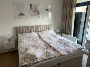 een slaapkamer met een bed met een wit dekbed bij Forst & Flair Apartment in Bad Harzburg +9 foto's