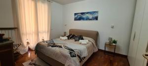 CASA AL LAGO D'ISEO VISTA PANORAMICA في بريدور: غرفة نوم بها سرير ولوحة على الحائط