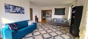 CASA AL LAGO D'ISEO VISTA PANORAMICA في بريدور: غرفة معيشة مع أريكة زرقاء وكرسي