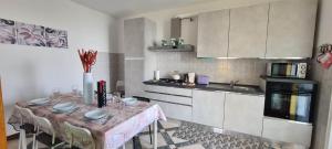 CASA AL LAGO D'ISEO VISTA PANORAMICA في بريدور: مطبخ مع طاولة مع كراسي وموقد