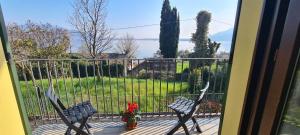 CASA AL LAGO D'ISEO VISTA PANORAMICA في بريدور: بلكونه مع كرسيين واطلاله على حديقه