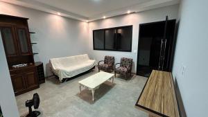 a living room with a couch and a tv on the wall at Casa Europa Barretos in Barretos