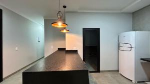 an empty room with a refrigerator and a hallway at Casa Europa Barretos in Barretos