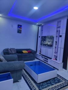 a living room with a couch and a blue ceiling at JKA 1-BEDROOM-Apart 24HRS POWER Unlimited WIFI , GARDEN PATIO AREA ,FREE DAILY HOUSEKEEPING in Lagos +30 photos