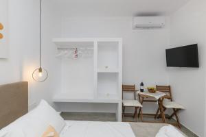 a bedroom with a bed and a table with chairs at Sunny & Blue 2 in Parasporos