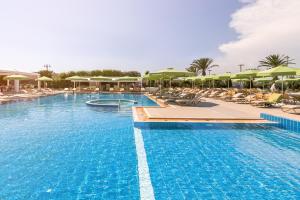 a large swimming pool with chairs and umbrellas at Divani Apollon Palace & Thalasso in Athens
