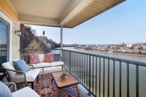 a balcony with a couch and a view of a river at Rivertowne Escape Downtown Knoxville in Knoxville