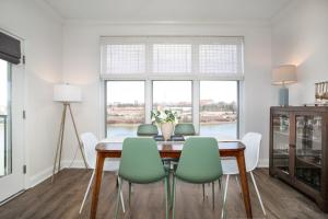 a dining room with a table and green chairs at Rivertowne Escape Downtown Knoxville in Knoxville