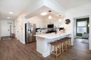 a kitchen with white cabinets and a large island with bar stools at Rivertowne Escape Downtown Knoxville in Knoxville