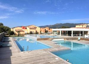 a large swimming pool with blue water in a resort at Corsica Bella 87 T2 Cosy piscines proche plage in Lecci