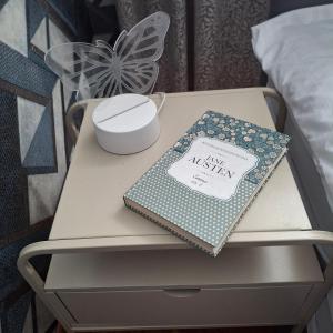 a table with a book on it on a bed at Apartament Agnes in Gniezno