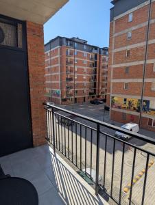 a balcony with a black door and some buildings at The Yellow Brick Apartment in Tbilisi City +11 photos