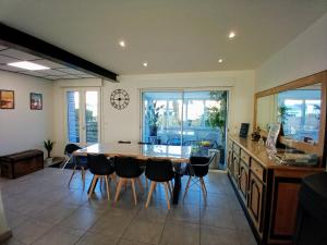a kitchen with a table and chairs and a clock on the wall at Villa Ptit Rene in Dunkerque