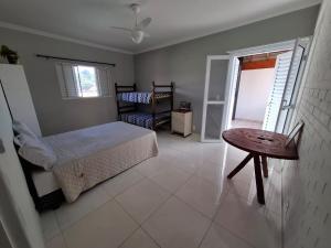a bedroom with a bed and a table and a window at CASA LORETO hospedagem, festas e eventos in Taubaté +40 photos