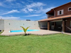 a swimming pool in a yard next to a house at CASA LORETO hospedagem, festas e eventos in Taubaté