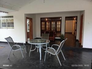 a glass table and chairs in a living room at Solaces transit residence in Liyanagemulla