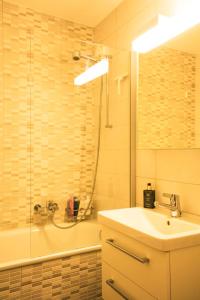 a bathroom with a sink and a shower and a tub at Apartment Le Hameau-21 by Interhome in Les Collons